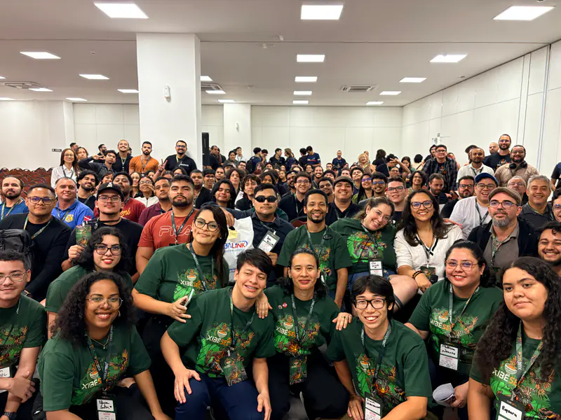 Foto coletiva de participantes e equipe no auditório, ao fim da edição.